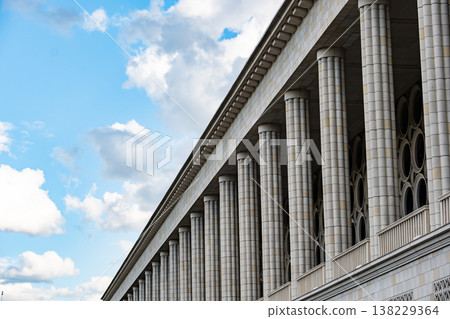 Modern classical architecture with repeating columns under a bright blue sky Modern classical architecture with repeating columns under a bright blue sky 138229364