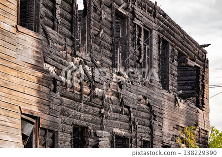 Charred wooden house facade remaining after a devastating fire disaster 138229390