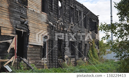Charred remains of an old log cabin building after a fire, showing decay and ruin Charred remains of an old log cabin building after a fire, showing decay and ruin 138229413