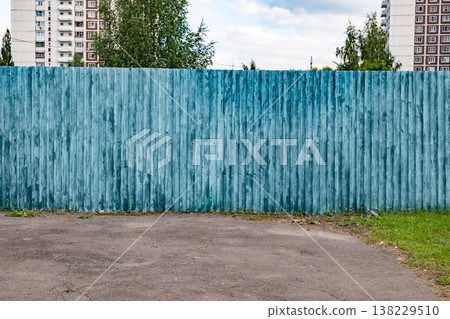 Teal corrugated metal fence in urban setting with building and trees Teal corrugated metal fence in urban setting with building and trees 138229510