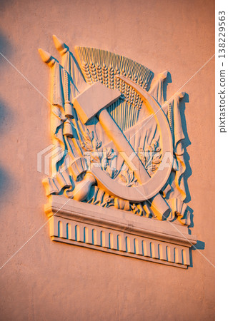 USSR hammer and sickle emblem relief on building wall, symbolizing communism USSR hammer and sickle emblem relief on building wall, symbolizing communism 138229563