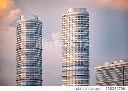 Modern residential towers with colorful facades rising into urban sky at sunset Modern residential towers with colorful facades rising into urban sky at sunset 138229706