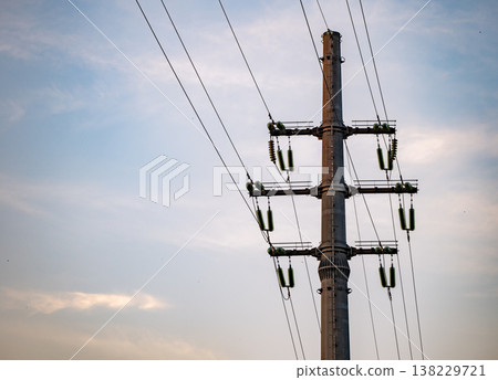 Power lines extending from an electric utility pole against a cloudy sky 138229721