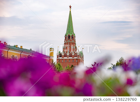 Kremlin's Troitskaya Tower rising above colorful flowers against a cloudy sky Kremlin's Troitskaya Tower rising above colorful flowers against a cloudy sky 138229760