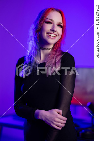 Young woman with vibrant hair smiling in a purple-lit studio Young woman with vibrant hair smiling in a purple-lit studio 138229913