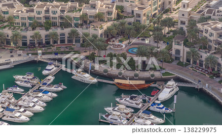 Aerial view on yachts floating in Dubai marina timelapse. White boats are in green canal water. Aerial view on yachts floating in Dubai marina timelapse. White boats are in green canal water. 138229975