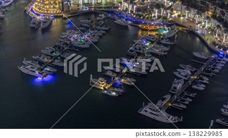 Aerial view on yachts floating in Dubai marina night timelapse. White boats are in canal water. Aerial view on yachts floating in Dubai marina night timelapse. White boats are in canal water. 138229985