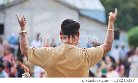 Man raising arms during Ganesh Chaturthi festival celebration in a crowd 138230337