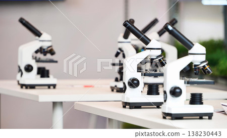 Multiple microscopes standing on tables in laboratory 138230443