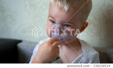 Small child undergoing medical nebulizer treatment for respiratory illness at home 138230524