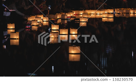 Floating paper river lanterns illuminating dark water at night Floating paper river lanterns illuminating dark water at night 138230570