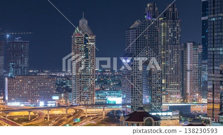 Aerial view of illuminated skyscrapers and road junction in Dubai timelapse 138230593