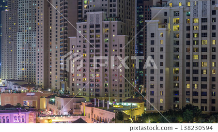 Aerial view of beach and tourists walking in JBR with skyscrapers night timelapse in Dubai, UAE 138230594
