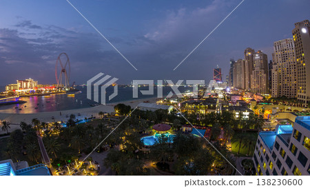 Aerial view of beach and tourists walking in JBR with skyscrapers day to night timelapse in Dubai, UAE 138230600