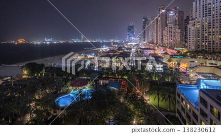 Aerial view of beach and tourists walking in JBR with skyscrapers night timelapse in Dubai, UAE Aerial view of beach and tourists walking in JBR with skyscrapers night timelapse in Dubai, UAE 138230612