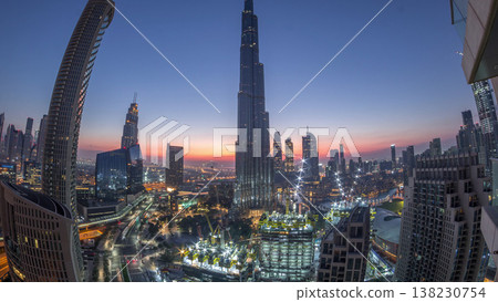 Panoramic skyline view of Dubai downtown before sunrise with mall, fountains and skyscrapers aerial night to day timelapse Panoramic skyline view of Dubai downtown before sunrise with mall, fountains and skyscrapers aerial night to day timelapse 138230754