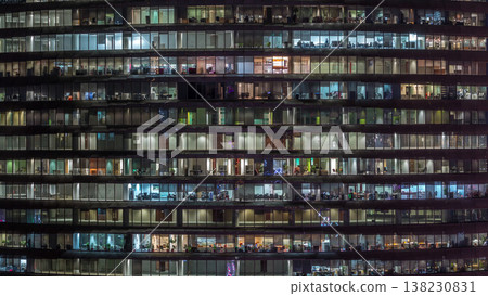 Working evening in glass office building with numerous offices with glass walls and windows timelapse 138230831