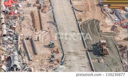 Excavator, truck and grader working at road construction site in Dubai downtown timelapse 138230877