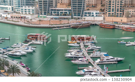 Luxury yachts parked on the pier in Dubai Marina bay with city aerial view timelapse Luxury yachts parked on the pier in Dubai Marina bay with city aerial view timelapse 138230904