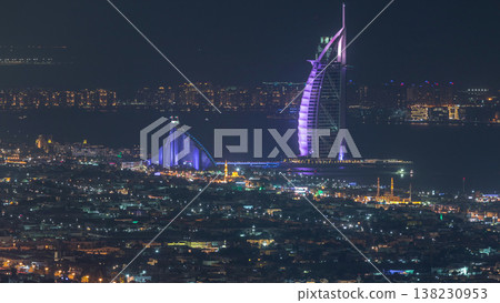Aerial view of Dubai city skyline at night with illuminated burj al arab hotel timelapse. Aerial view of Dubai city skyline at night with illuminated burj al arab hotel timelapse. 138230953