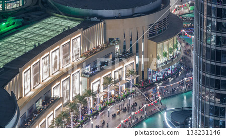 Lots of tourists walking near fountains and shopping mall in Dubai downtown night timelapse 138231146