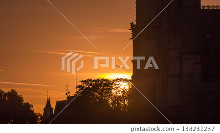 Rear view of Notre Dame De Paris cathedral at sunset with sun in the frame timelapse. 138231237