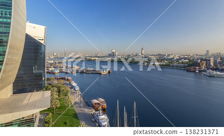Dubai creek landscape timelapse with boats and ship in port and modern buildings in the background during sunset Dubai creek landscape timelapse with boats and ship in port and modern buildings in the background during sunset 138231371