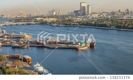 Dubai creek landscape timelapse with boats and ship in port and modern buildings in the background during sunset 138231374