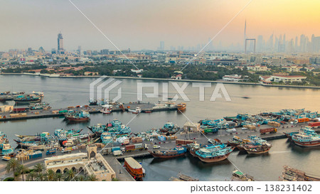 Dubai creek landscape timelapse with boats and ship in port and modern buildings in the background during sunset Dubai creek landscape timelapse with boats and ship in port and modern buildings in the background during sunset 138231402