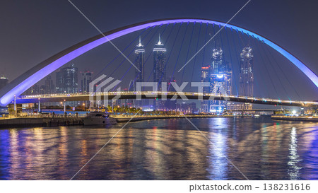 Futuristic Pedestrian Bridge over the Dubai Water Canal Illuminated at Night timelapse, UAE. Futuristic Pedestrian Bridge over the Dubai Water Canal Illuminated at Night timelapse, UAE. 138231616