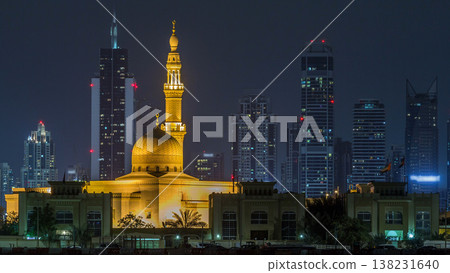 Modern Dubai city skyline timelapse with Rashid Al Hadeeth Mosque at night with illuminated skyscrapers over water surface Modern Dubai city skyline timelapse with Rashid Al Hadeeth Mosque at night with illuminated skyscrapers over water surface 138231640