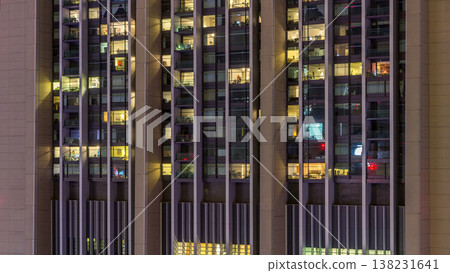 Windows of the multi-storey building of glass and steel lighting inside and moving people within timelapse Windows of the multi-storey building of glass and steel lighting inside and moving people within timelapse 138231641