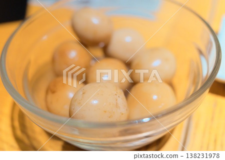 一道小菜，上面放著烤鵪鶉蛋，用稻草包裹著烤製而成。 138231978
