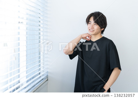 Young man relaxing by the window Young man relaxing by the window 138232057