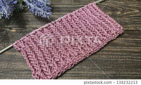 A relief openwork pattern knitted with colored yarn on a wooden background 138232213