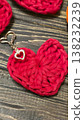 Red knitted heart-shaped keychain on a wooden background. Handmade. 138232239