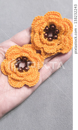 Crochet orange flowers with beads on a gray background. Design example. 138232243