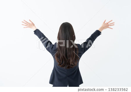 一位女商人的背影,她舉起雙臂慶祝。 一位女商人的背影,她舉起雙臂慶祝。 138233562