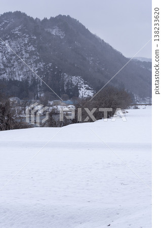 A winter landscape of Minami-Aizu in the snow, with vast snowfields and snow-covered mountain ranges stretching out before you in the countryside. 138233620