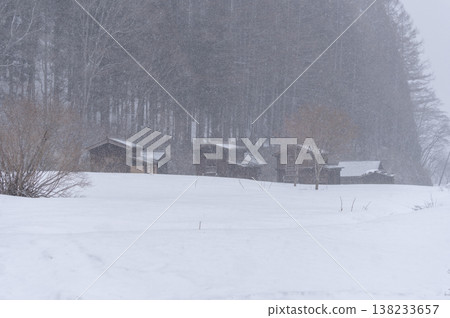 A traditional wooden storehouse stands amidst the snow-covered plains of Hinoemata Village in winter. 138233657