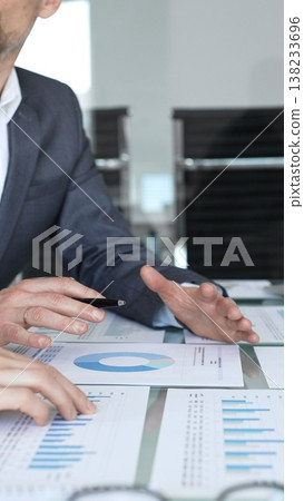 Business professionals analyzing financial growth data on a laptop and reports during a corporate meeting, collaborating on strategy and investment planning, reviewing market performance Business professionals analyzing financial growth data on a laptop and reports during a corporate meeting, collaborating on strategy and investment planning, reviewing market performance 138233696