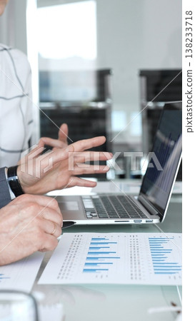 Business professional's hand pointing at financial graphs and charts on performance reports during a meeting, analyzing data for strategic planning and decision making Business professional's hand pointing at financial graphs and charts on performance reports during a meeting, analyzing data for strategic planning and decision making 138233718