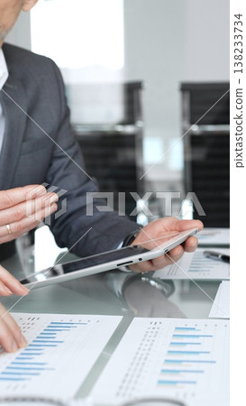 Business professionals analyzing financial data reports, charts, and graphs during a corporate meeting, discussing statistics and planning strategies in an office Business professionals analyzing financial data reports, charts, and graphs during a corporate meeting, discussing statistics and planning strategies in an office 138233734