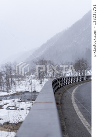 A winter scene overlooking the hazy mountains of Minami-Aizu and the Inagawa River as snow falls. A winter scene overlooking the hazy mountains of Minami-Aizu and the Inagawa River as snow falls. 138233751