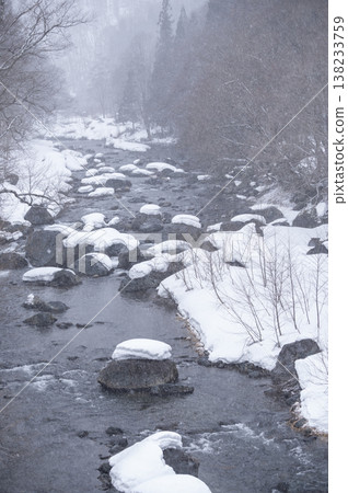 The Inagawa River flows through the snow-covered village of Hinoemata, with snow-capped rocks and a wintery mountain stream landscape. The Inagawa River flows through the snow-covered village of Hinoemata, with snow-capped rocks and a wintery mountain stream landscape. 138233759