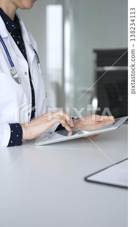 Doctor woman using digital tablet for medical consultation, female physician working with patient data in clinic. Medicine, healthcare and science concept Doctor woman using digital tablet for medical consultation, female physician working with patient data in clinic. Medicine, healthcare and science concept 138234113