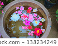 An overhead view of a flower arrangement floating in a water basin, a Japanese-style image that can be used for garden tourism or spring promotions. 138234249