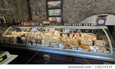 A variety of local Greek fresh cheeses are lined up in the showcase, as well as preserved foods in jars A variety of local Greek fresh cheeses are lined up in the showcase, as well as preserved foods in jars 138234339