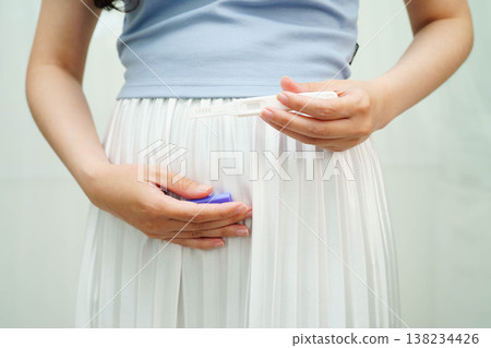 Asian holding pregnancy test for female of ovulation day, fetus, maternity, childbirth, birth control. Asian holding pregnancy test for female of ovulation day, fetus, maternity, childbirth, birth control. 138234426