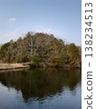 A hill casts its shadow on the water surface of the embankment. 138234513